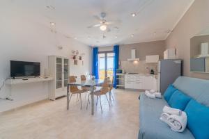 a living room with a blue couch and a table at C 207 Puntavilla - Vista Piscina in La Maddalena