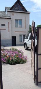 a house with a bunch of flowers in a parking lot at Julia's Place - Apartment, Garden & BBQ in Vagharshapat