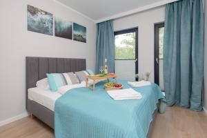 a bedroom with two beds with blue sheets and a table at Little Laguna Apartments SPA & Gym by Noclegi Renters in Międzywodzie