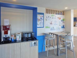 a kitchen with a counter and a table and chairs at Hop Inn Nakhon Ratchasima City Center in Nakhon Ratchasima