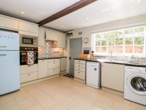 a large kitchen with a washer and dryer in it at Kemps Yard Retreat in Thirsk
