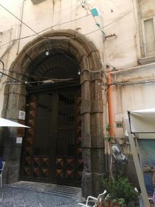 ナポリにあるRoyal Boutique Napoliの大きな木製のドアのある建物の入口