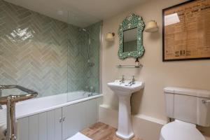 La salle de bains est pourvue d'un lavabo, d'une baignoire et de toilettes. dans l'établissement The Cottage in the Clouds, à Marlborough