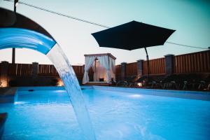 una fuente de agua en una piscina con sombrilla en Cartagena Villa & Spa, en Brčko 15 fotos más