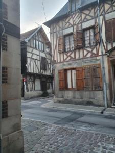 an old building with wooden doors on a street at Le logis du clocher in Troyes