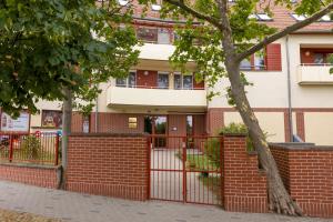 a brick building with a gate and a fence at Szent Imre Apartman in Veszprém
