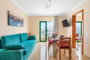 een woonkamer met een blauwe bank en een tafel bij Las Adelfas in Puerto del Carmen
