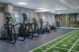 a fitness room with treadmills and elliptical machines at Horwood House Hotel in Milton Keynes