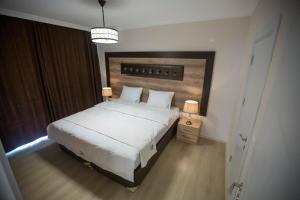 بلاك روز في طرابزون: غرفة نوم مع سرير أبيض كبير مع اللوح الأمامي الخشبي