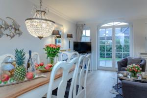 uma cozinha e sala de estar com mesa e cadeiras em Ferienhaus Sylter Sehnsucht em Westerland