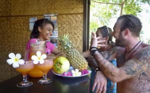 a group of people sitting at a table with fruit at Villas Ganjor in Gili Meno