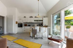 une cuisine avec des placards blancs et une table avec des tapis jaunes dans l'établissement Charmantes Loft Appartement, à Haan