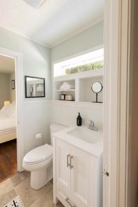 Baño blanco con aseo y lavamanos en Cute n' Comfy Capers, en Columbia