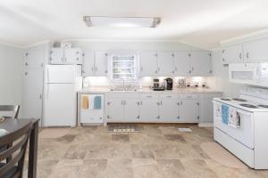 a kitchen with white cabinets and white appliances at Cute n' Comfy Capers in Columbia