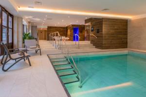a swimming pool with a stairway in a building at Horwood House Hotel in Milton Keynes