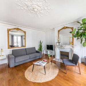 ein Wohnzimmer mit einem Sofa und einem Kamin in der Unterkunft Appartements Bergère in Paris