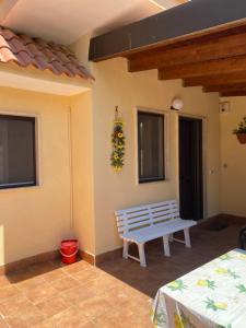 a porch with a bench and a wreath on the wall at Appartamento l’Akorea in Convento