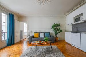 ein Wohnzimmer mit einem Sofa und einem Tisch in der Unterkunft Appartements Bergère in Paris