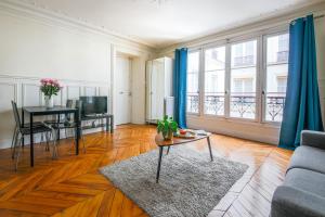ein Wohnzimmer mit einem Sofa und einem Tisch in der Unterkunft Appartements Bergère in Paris