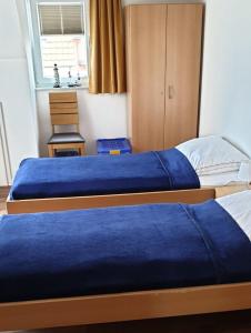 2 bedden met blauwe lakens in een slaapkamer bij Ostseebrise 14 - Großenbrode in Großenbrode