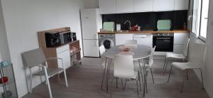 a kitchen with a table and chairs in a room at Maison ville agréable in Riorges