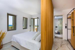 a bedroom with a bed and a bathroom at Golden Bay luxury villas and suites in Chrissi Akti