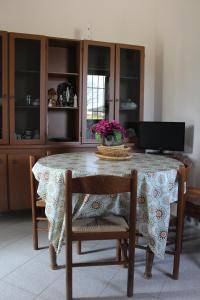 a dining room table with a floral table cloth and chairs at Casa Angelica, comoda casa nella campagna pugliese in Fasano