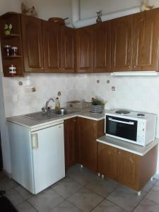 a kitchen with wooden cabinets and a white stove top oven at Magda Studios - Vigla Studio in Zagora