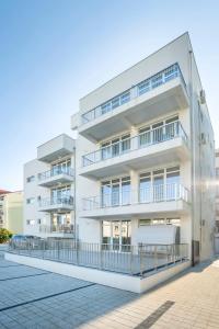an apartment building with balconies on a street at Ono Aparthotel in Mamaia Sat/Năvodari