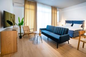 a living room with a blue couch and a bed at Ono Aparthotel in Mamaia Sat/Năvodari