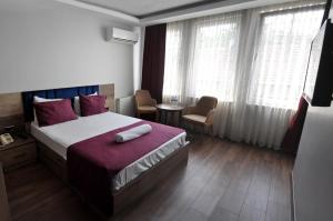 um quarto de hotel com uma cama, uma mesa e janelas em Waha Hotel em Bursa