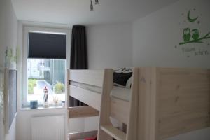 een slaapkamer met een houten stapelbed en een raam bij Meeresrauschen 3 - Großenbrode in Großenbrode