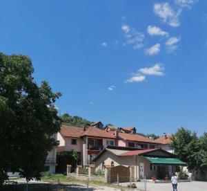 a person walking in front of a house at Apartman Dukat in Višegrad