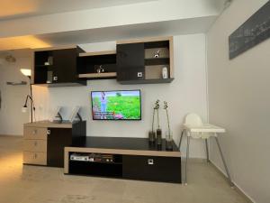 un salon avec une télévision à écran plat sur un mur dans l'établissement Ammi Residence - Mamaia Nord, à Mamaia Nord – Năvodari