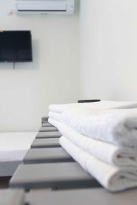 a stack of white towels on a bed at Pansion Artemis in Mavrovouni +120 photos