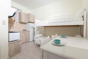 a kitchen and dining room with a bunk bed at Pansion Artemis in Mavrovouni