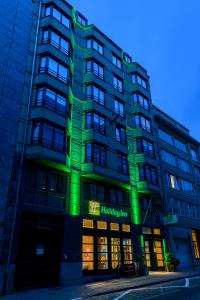 a tall building with green lights on it at Holiday Inn Brussels Schuman, an IHG Hotel in Brussels