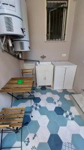 cocina con suelo azul y blanco y bancos en Maison Don Turillo, en SantʼAlessio Siculo
