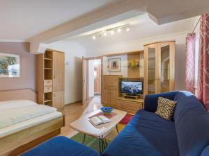 een kamer met een bed, een bank en een tv bij Haus Agnes Daum in Hippach