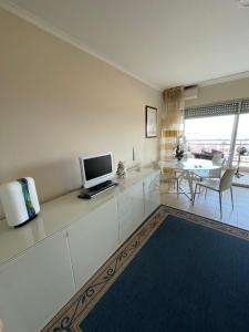 un soggiorno con TV e tavolo da pranzo di Eden Residence a Cannes