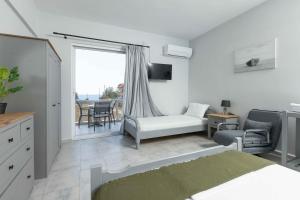 a bedroom with a bed and a couch and a chair at Pansion Artemis in Mavrovouni