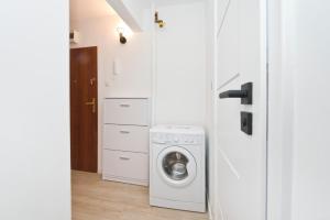 a laundry room with a washer and dryer at YOURAPART Przymorze Piastowska in Gdańsk