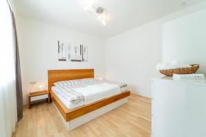 een slaapkamer met een bed in een witte kamer bij Rosi's Wörthersee apartment in Ludmannsdorf