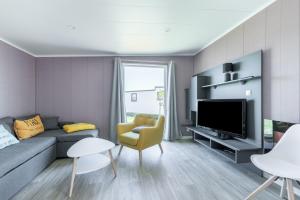 a living room with a couch and a tv at Chalet pour 4 dans une residence avec piscine couverte in Brétignolles-sur-Mer