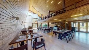 a restaurant with wooden walls and tables and chairs at Cuibul de Lemn in Râşnov