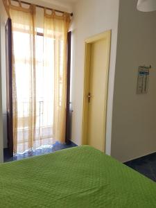 - une chambre avec un lit vert et une fenêtre dans l'établissement Lipari Centro Storico Flat 7 min from port, à Lipari