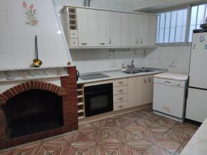 a kitchen with a fireplace and a sink and a refrigerator at Casa Ventana Cazorla in Cazorla