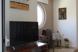 Televízia a/alebo spoločenská miestnosť v ubytovaní Dimokritos Apartment