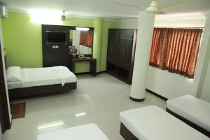 Postel nebo postele na pokoji v ubytování Jeyam Residency, Kumbakonam