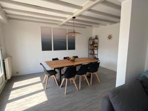 een eetkamer met een houten tafel en stoelen bij L ETOILE DE MALO in Duinkerke +1 foto